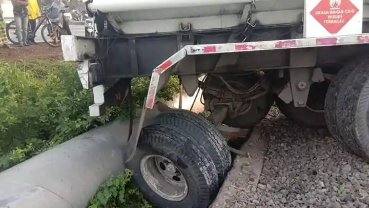 Foto - Ajaib! Hindari Kendaraan Lain, Truk Tangki Isuzu Giga Ini 'Lompat' ke Jalur Rel Kereta Api